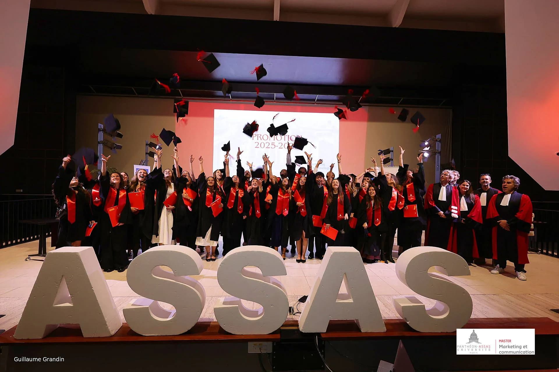 Graduation of the Assas Master’s in Marketing and Communication: students throw their caps, Laurent Florès in academic robe on the right.